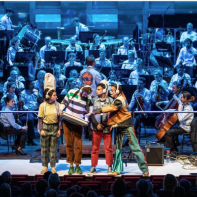 podium met optredende artiesten en orkest op achtergrond