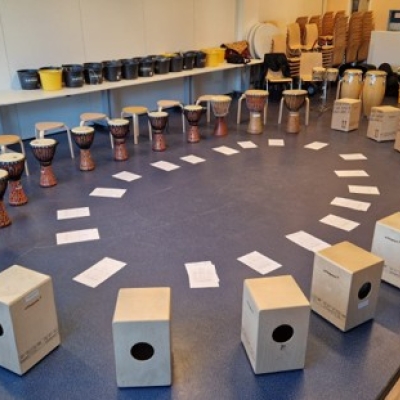 De afbeelding toont een kring vol percussie