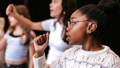 De afbeelding toont jonge meiden tijdens een theaterles/muscial