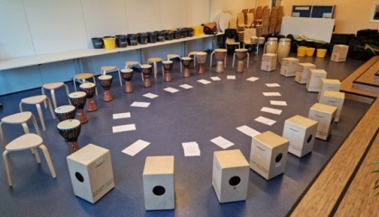 De afbeelding toont een kring vol percussie
