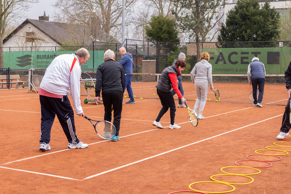 senioren die tennisles krijgen